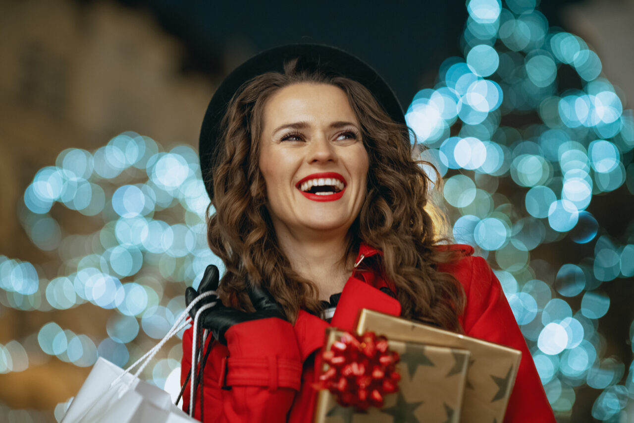 A photo of a woman carrying gifts represents Christmas shoppers.