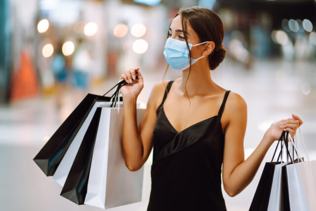 A woman with a mask returns from shopping, satisfied with luxury customer service experience. 