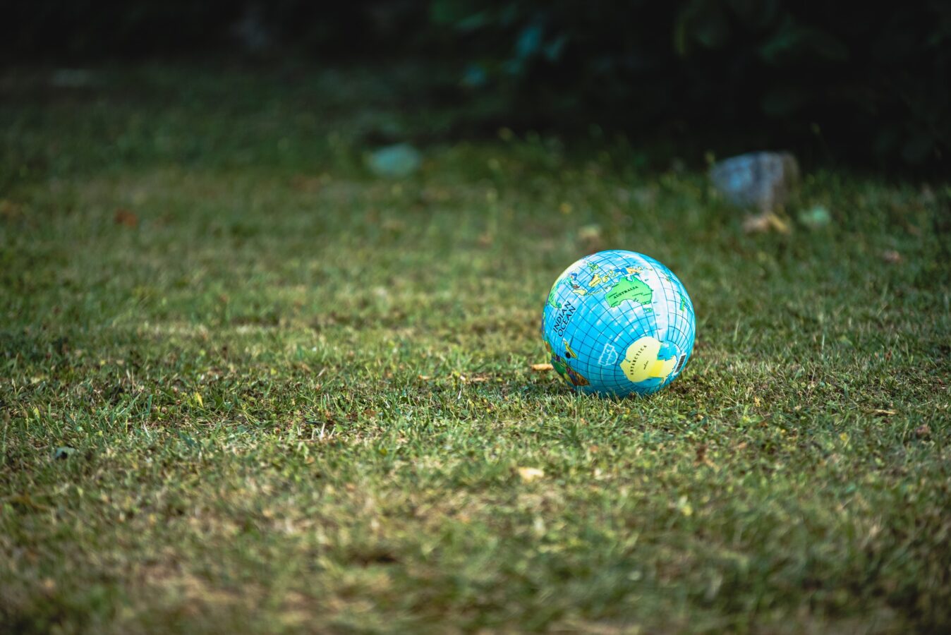 A world toy on the grass represents the importance of having sustainability development goals.