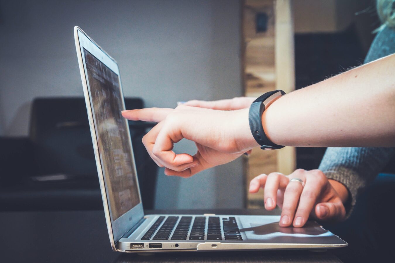 a finger pointing at the computer screen and talking about using business intelligence