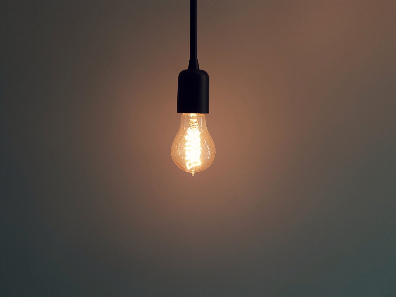A lightbulb glowing in the dark represents innovation in turbulent times.