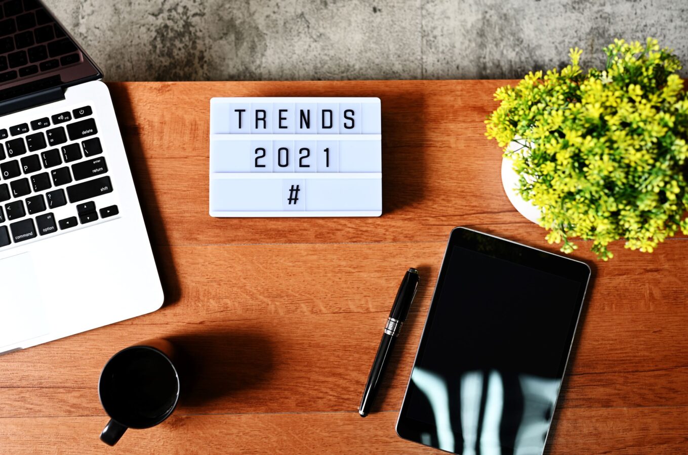 A board on the desk contains the words Customer Experience Trends in 2021.