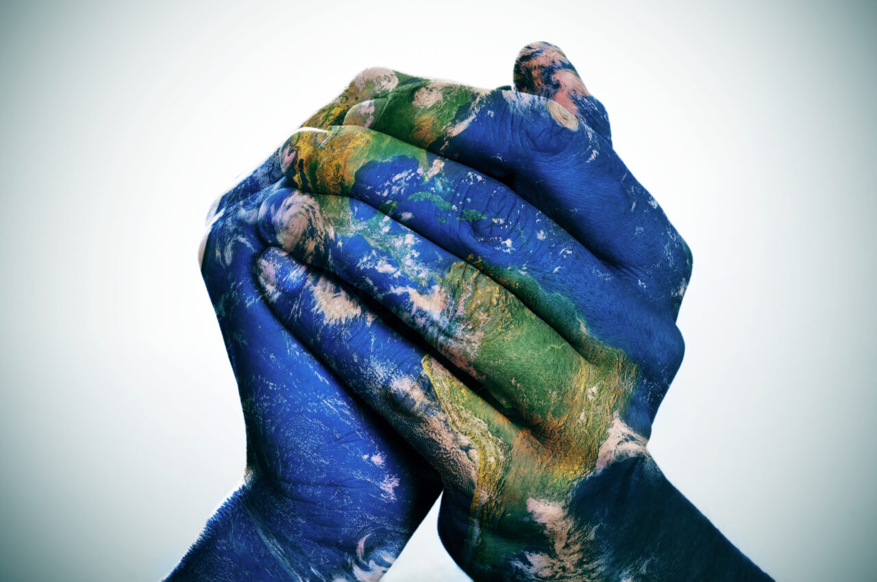 World map painted on hands to show cultural diversity.