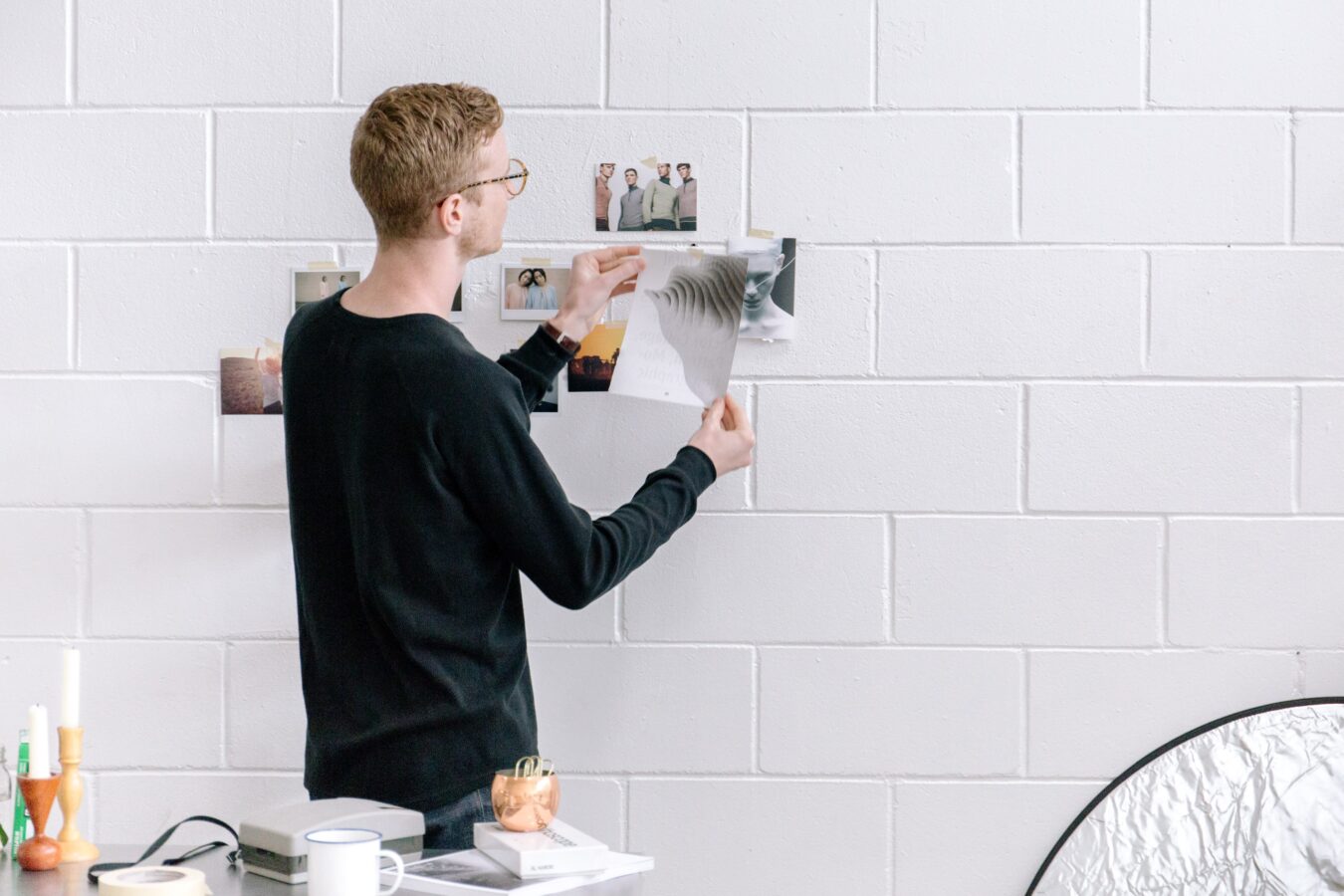 An employee adding photos to the wall to map and rethink customer experience.