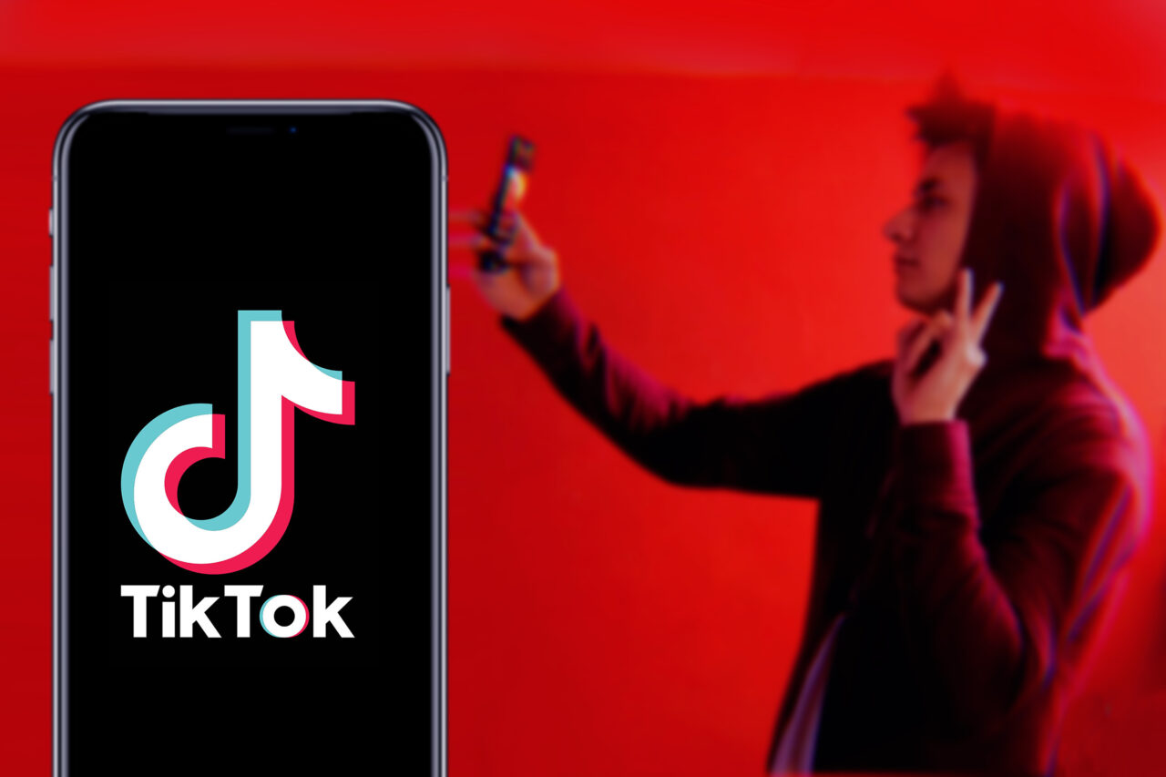 an image showing a young person recording himself on tiktok. 