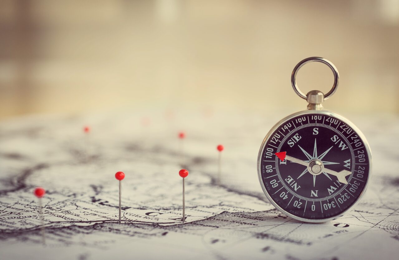 A compass and a map represent the customer journey management.