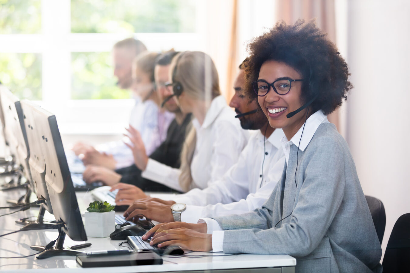 a group of smiling people working at a customer support centre