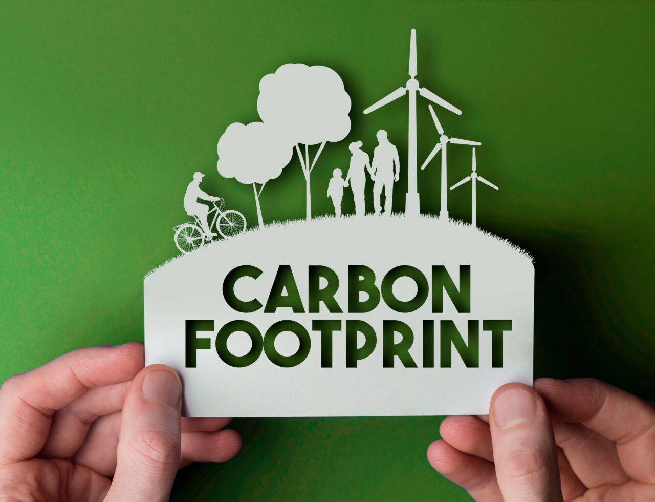 An image showing a person holding a carton on which is written Carbon footprint. 