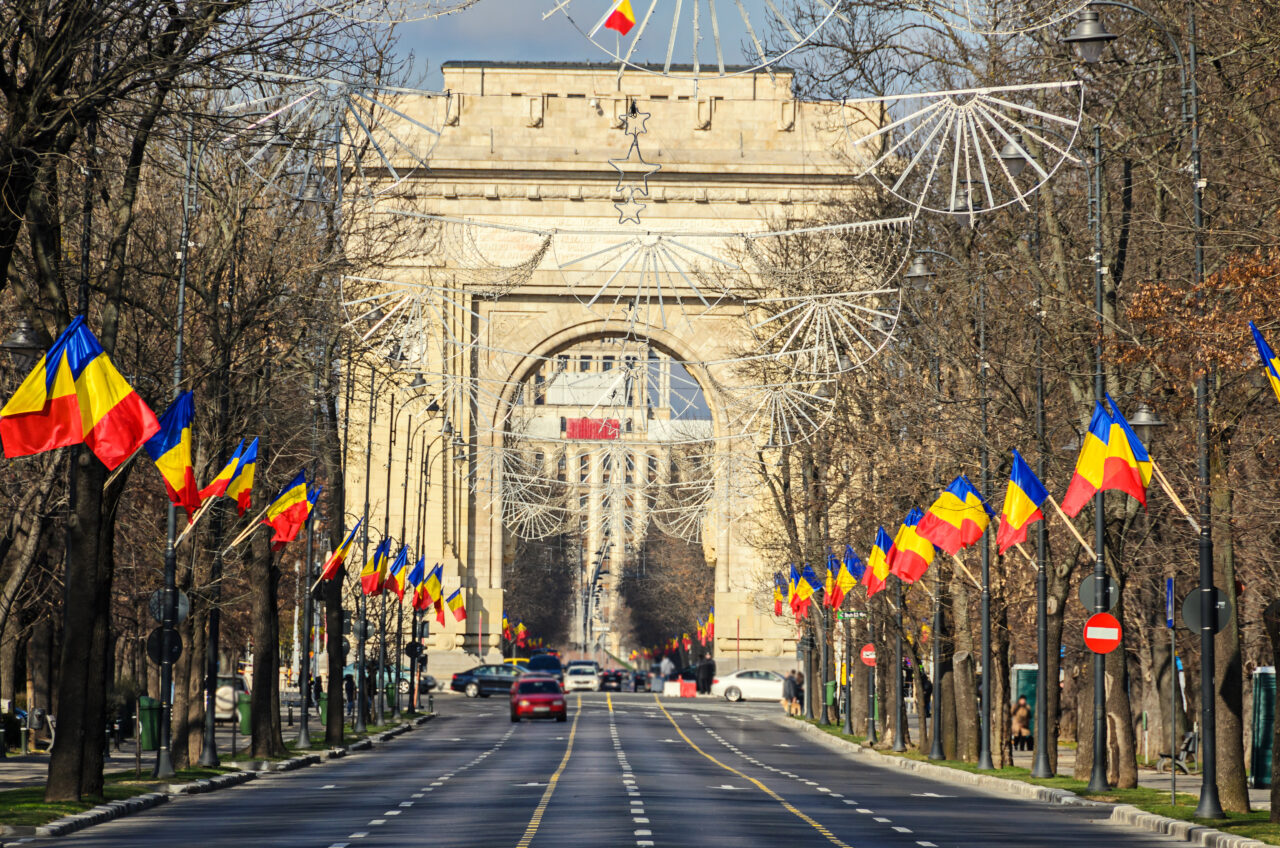 The Arch of Triumph (Arcul de Triumf) from Bucharest Romania, National Day with romanian flags, view from Kisseleff Avenue.