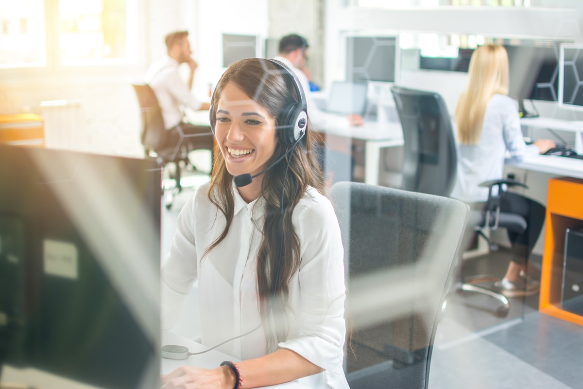 Friendly female call center operator working in office