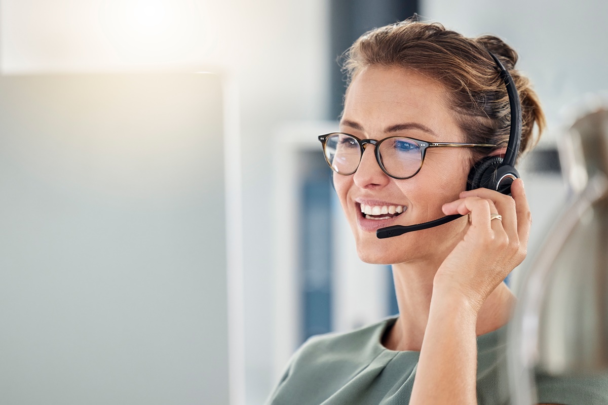 Happy call center woman consulting customer for customer support, help or telemarketing sales.