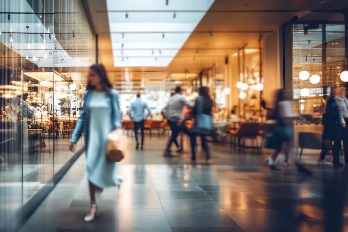 Blurred background of a modern shopping mall with some shoppers. Shoppers walking at shopping center, motion blur. Abstract motion blurred shoppers with shopping bags, ai