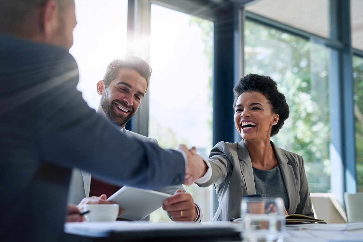 Meeting, partnership and business people shaking hands in the office for a deal, collaboration or onboarding. Diversity, professional and employees with handshake for agreement, welcome or greeting